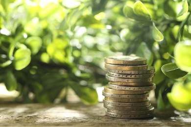 Photo of Stacked euro coins on wooden table outdoors