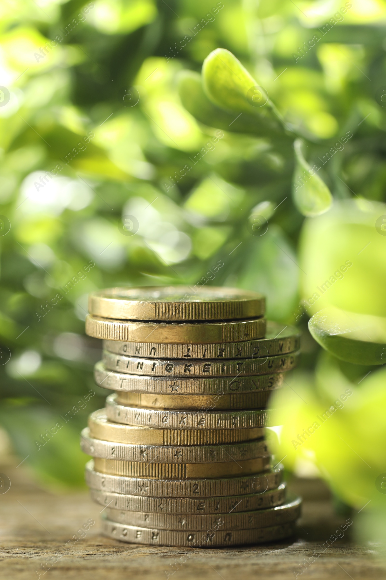 Photo of Stacked euro coins on wooden table outdoors