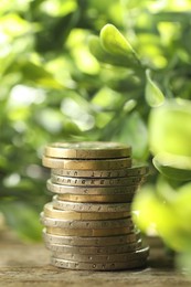 Stacked euro coins on wooden table outdoors