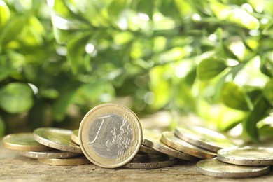 Photo of Many euro coins on wooden table outdoors