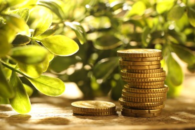 Photo of Stacked euro coins on wooden table outdoors