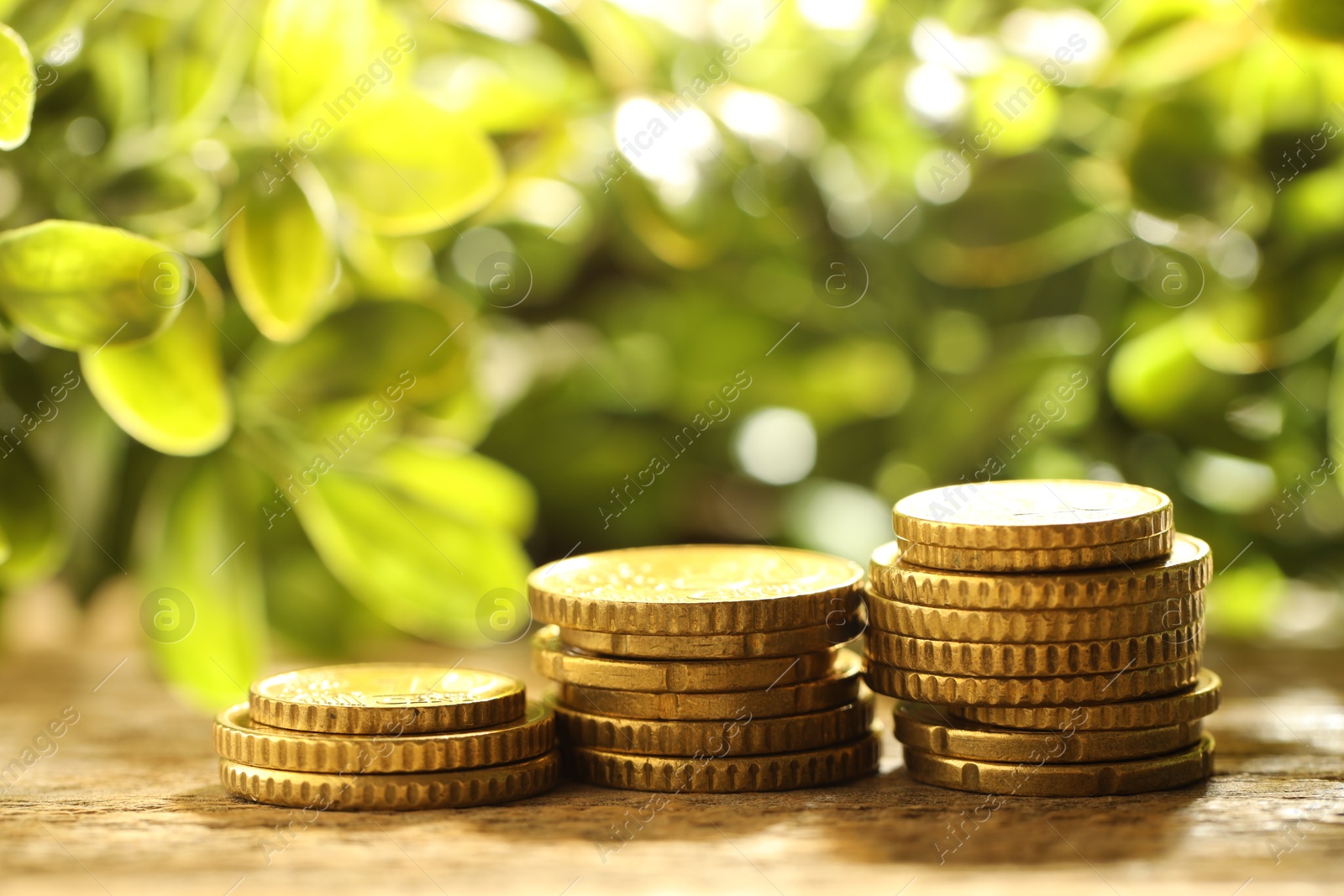 Photo of Stacked euro coins on wooden table outdoors