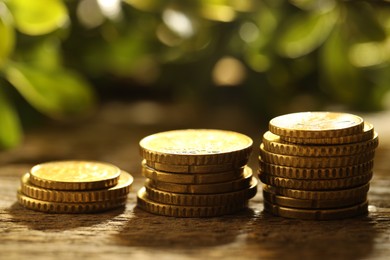 Photo of Stacked euro coins on wooden table outdoors