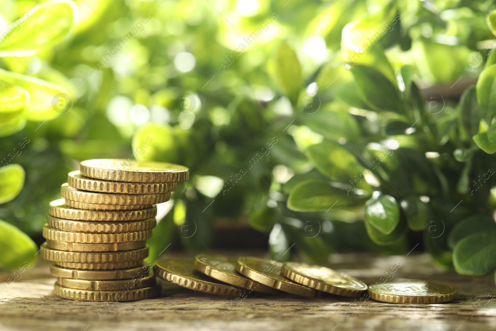 Photo of Stacked euro coins on wooden table outdoors