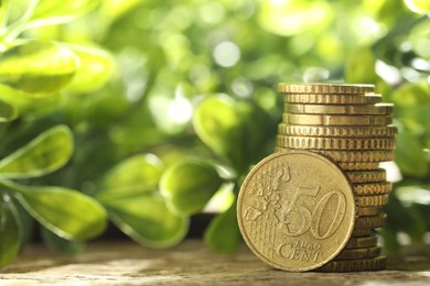 Photo of Stacked euro coins on wooden table outdoors