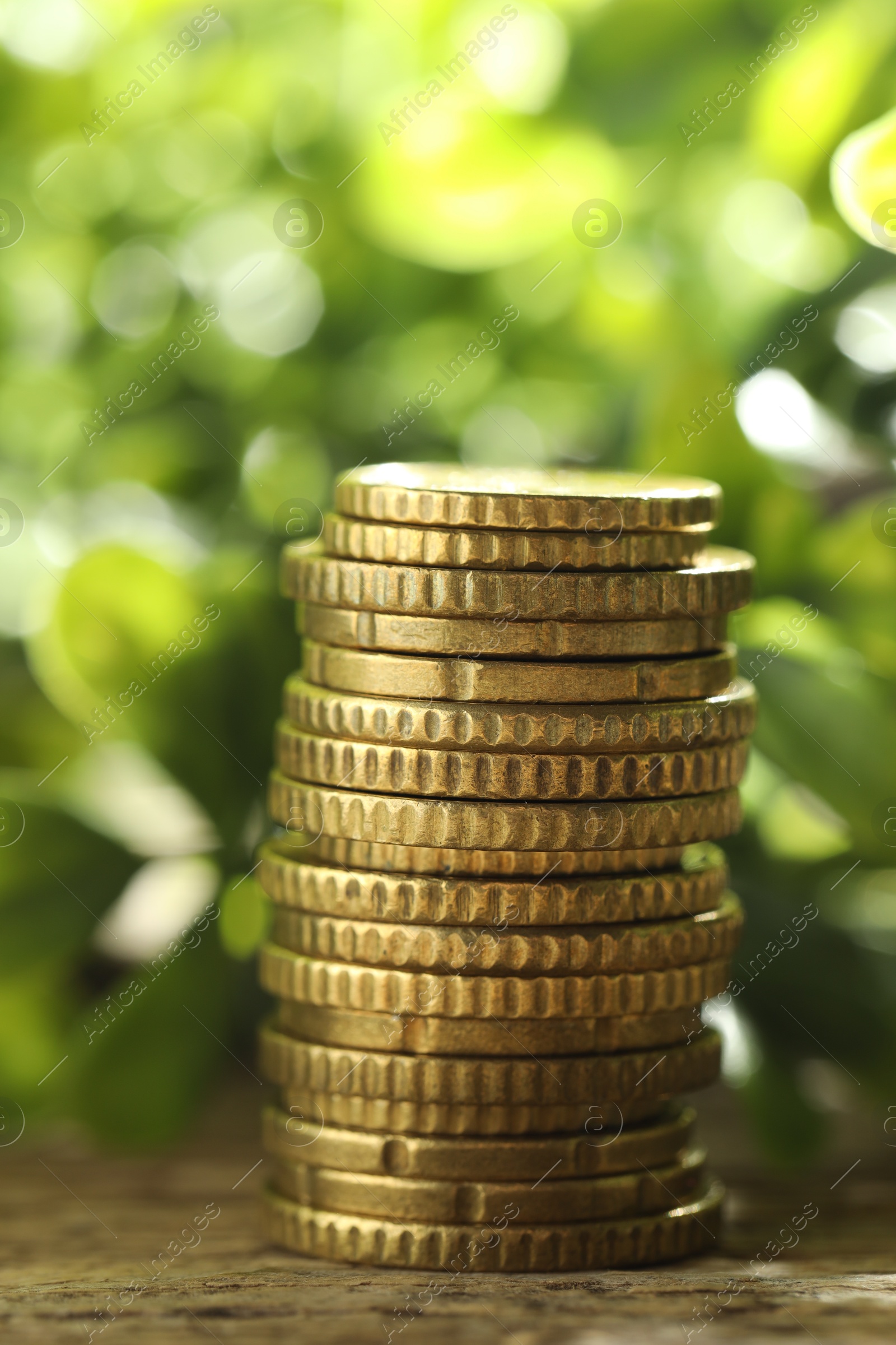 Photo of Stacked euro coins on wooden table outdoors