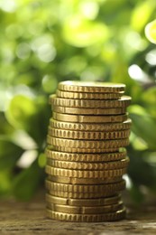 Photo of Stacked euro coins on wooden table outdoors