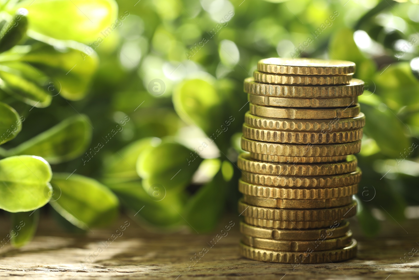 Photo of Stacked euro coins on wooden table outdoors