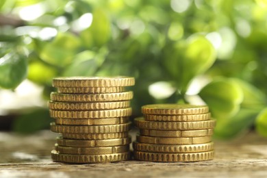 Photo of Stacked euro coins on wooden table outdoors