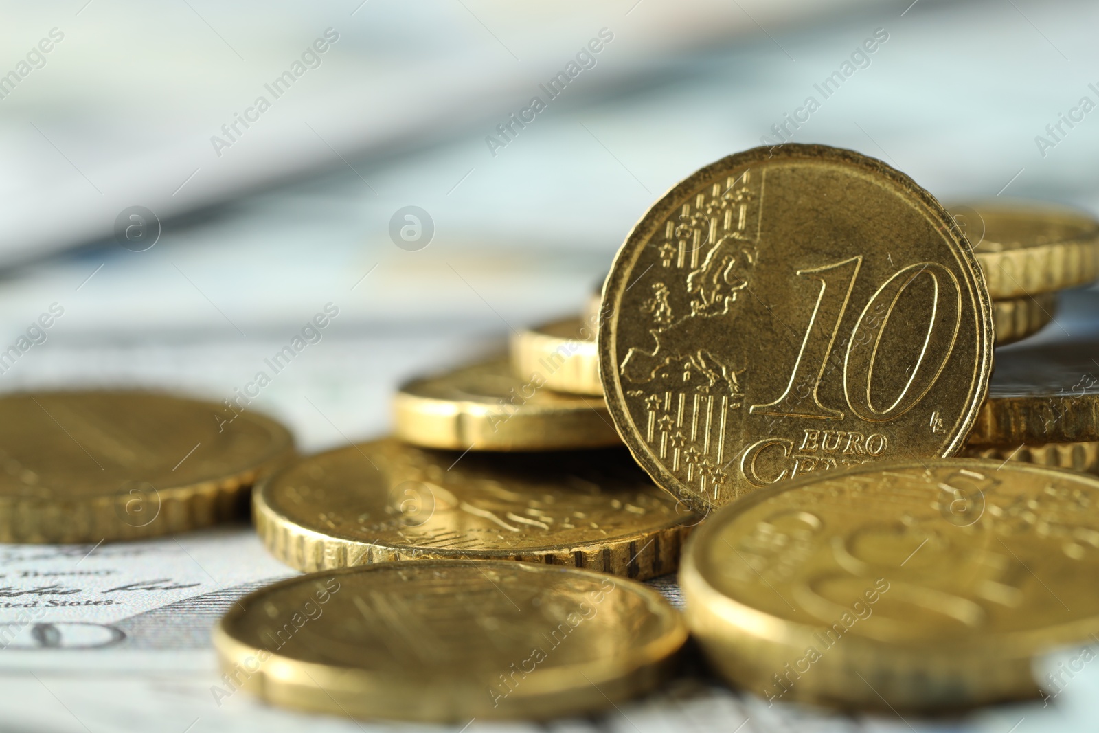 Photo of Many euro coins on dollar banknotes, closeup