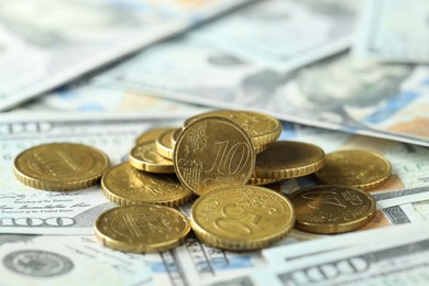 Photo of Many euro coins on dollar banknotes, closeup