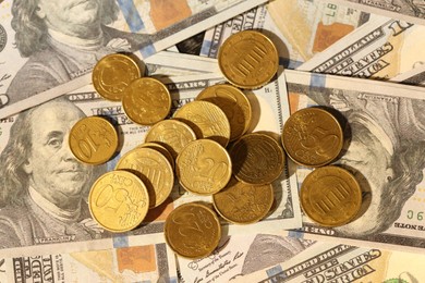 Photo of Many euro coins on dollar banknotes, top view