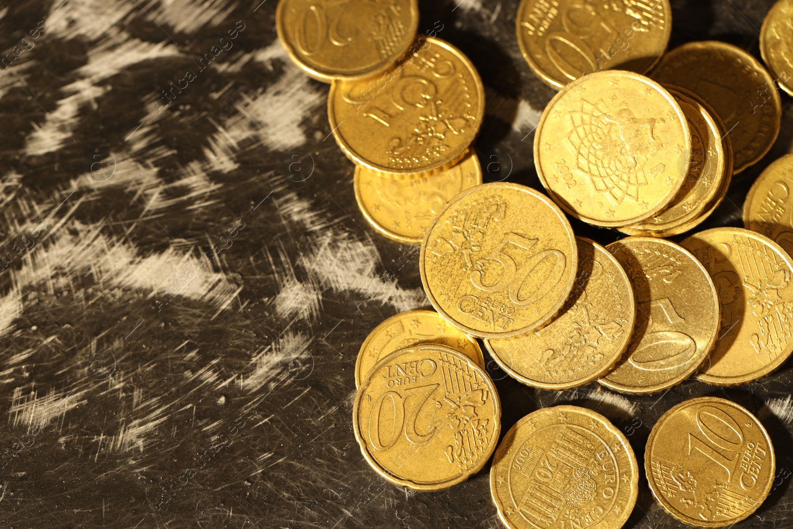 Photo of Many euro coins on dark table, top view. Space for text