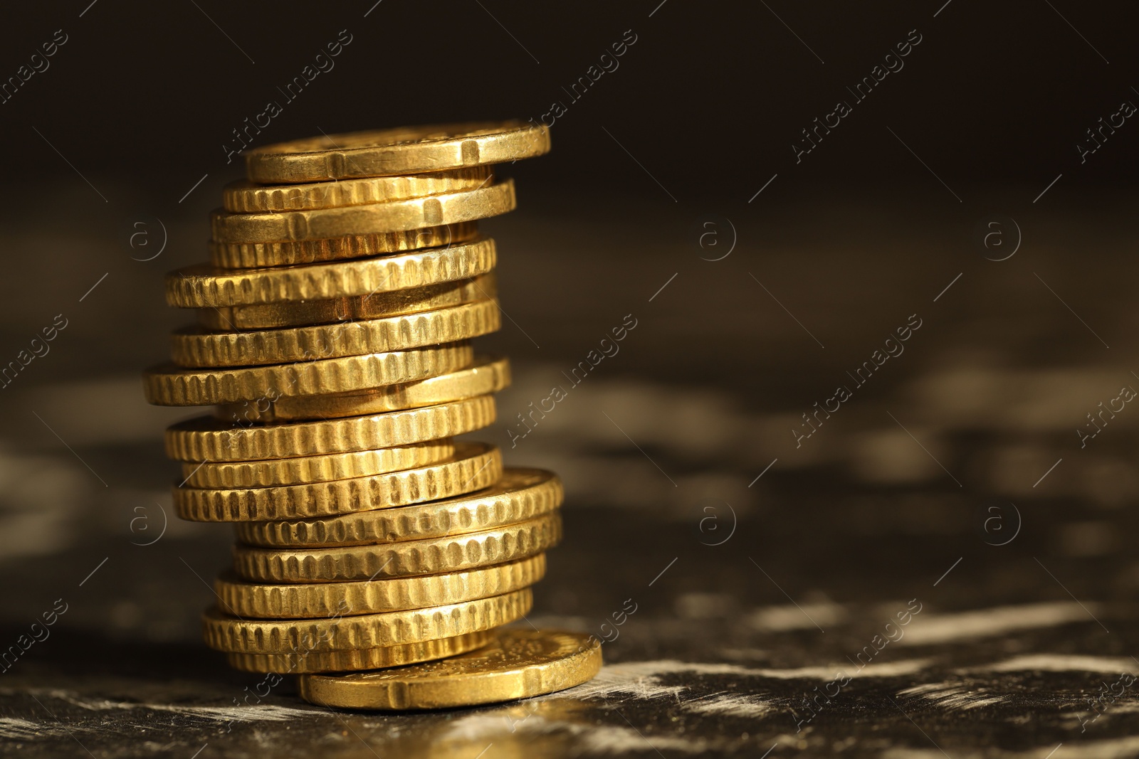 Photo of Stacked euro coins on dark table, closeup. Space for text