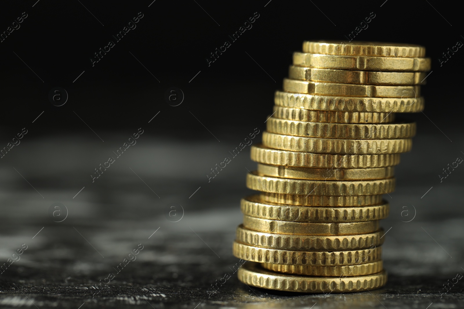 Photo of Stacked euro coins on dark table, closeup. Space for text