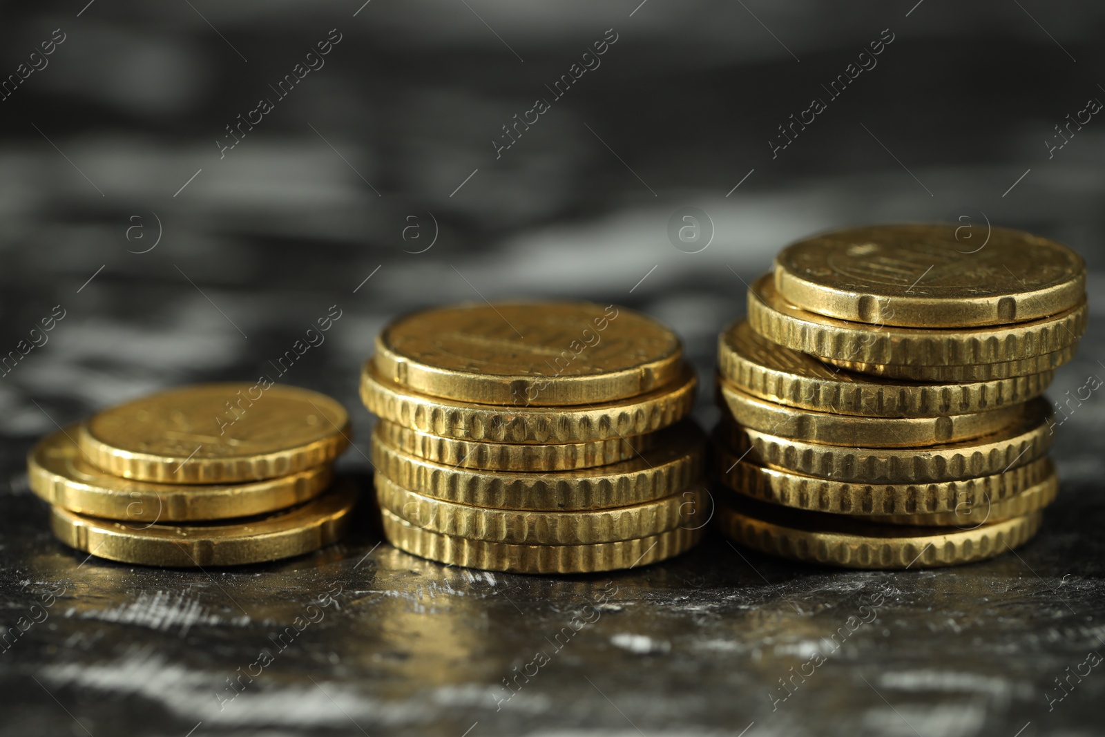 Photo of Stacked euro coins on dark table, closeup