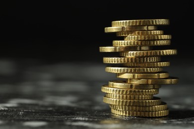 Photo of Stacked euro coins on dark table, closeup. Space for text