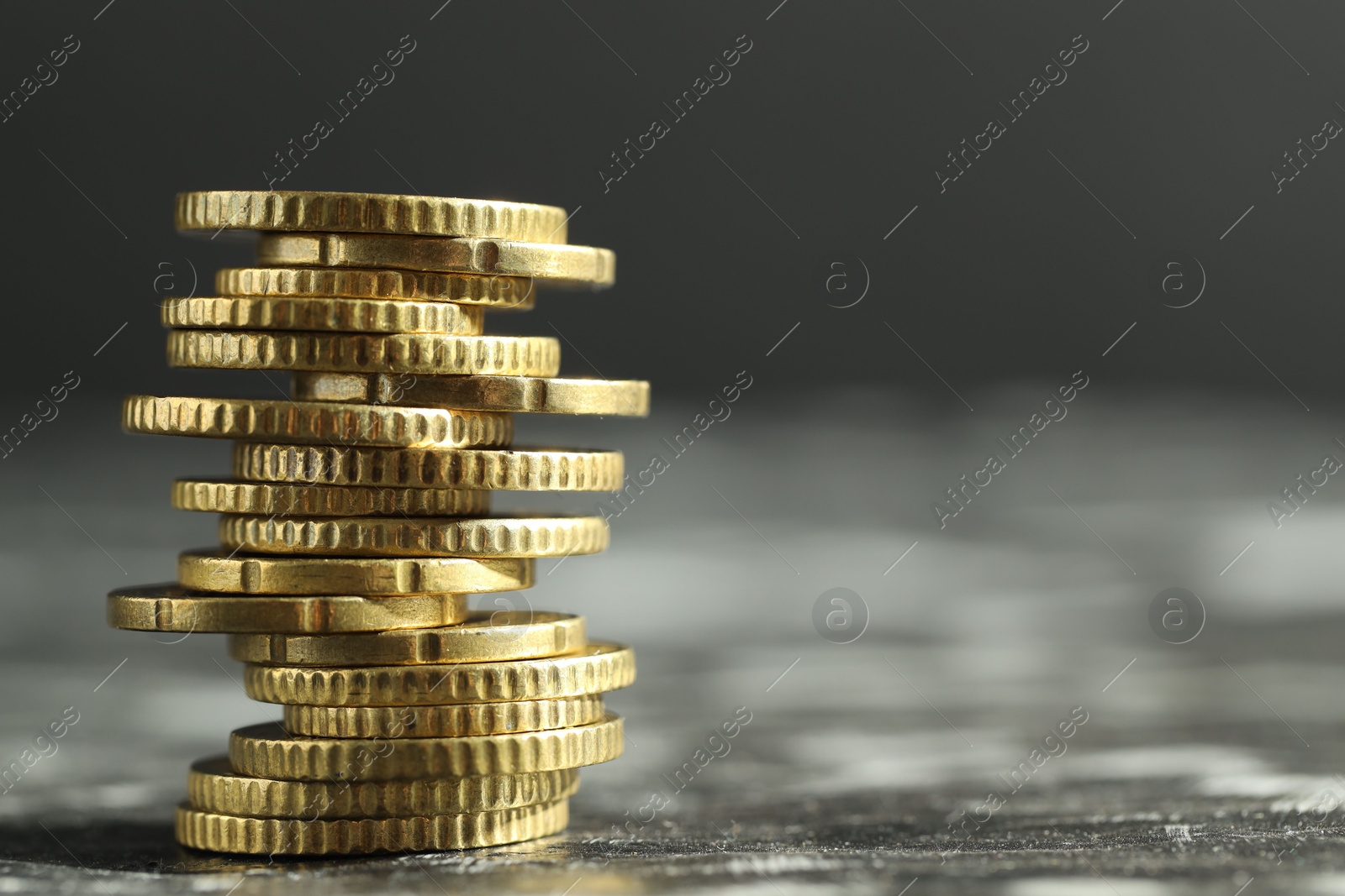 Photo of Stacked euro coins on dark table, closeup. Space for text