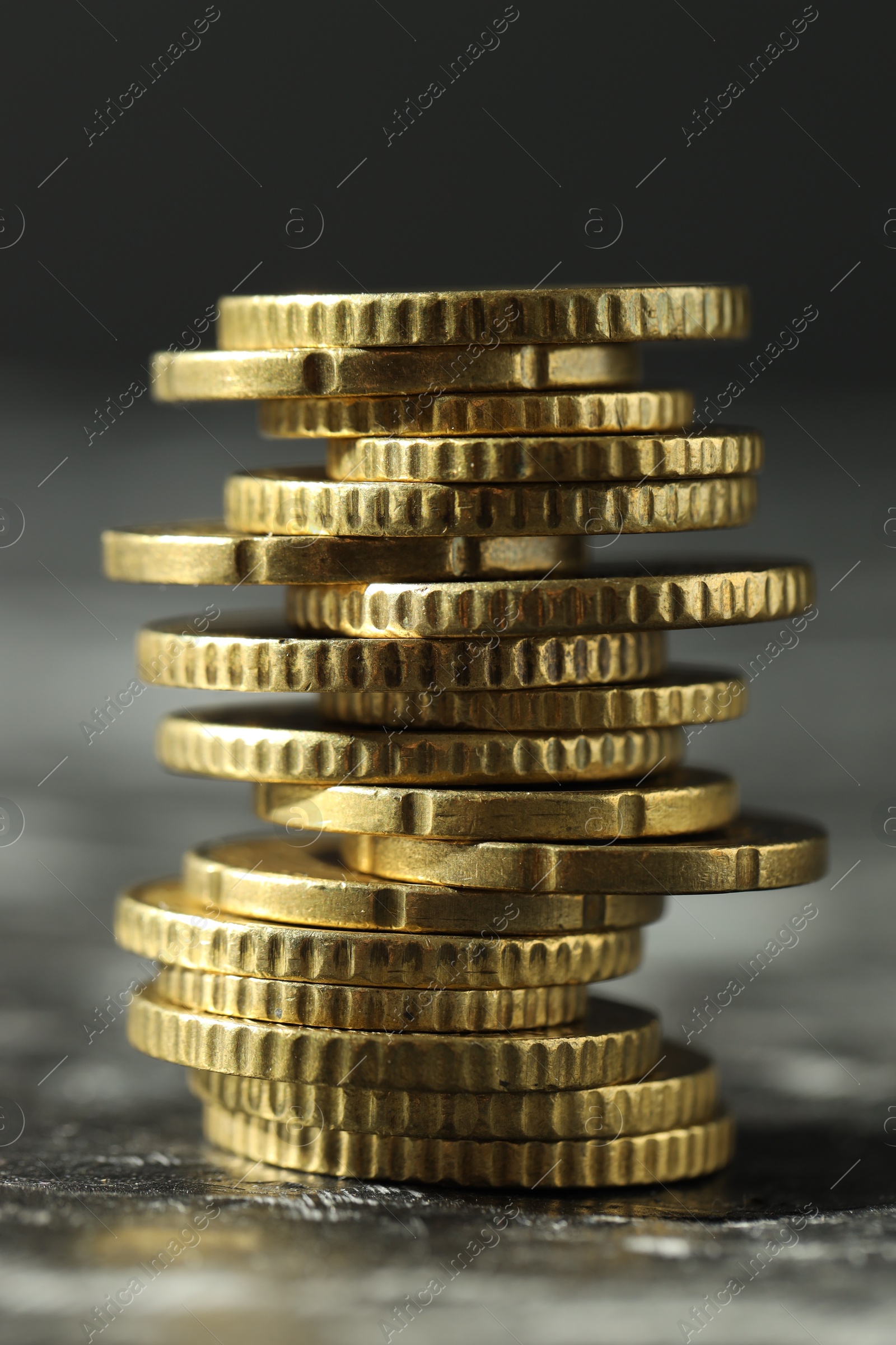 Photo of Stacked euro coins on dark table, closeup