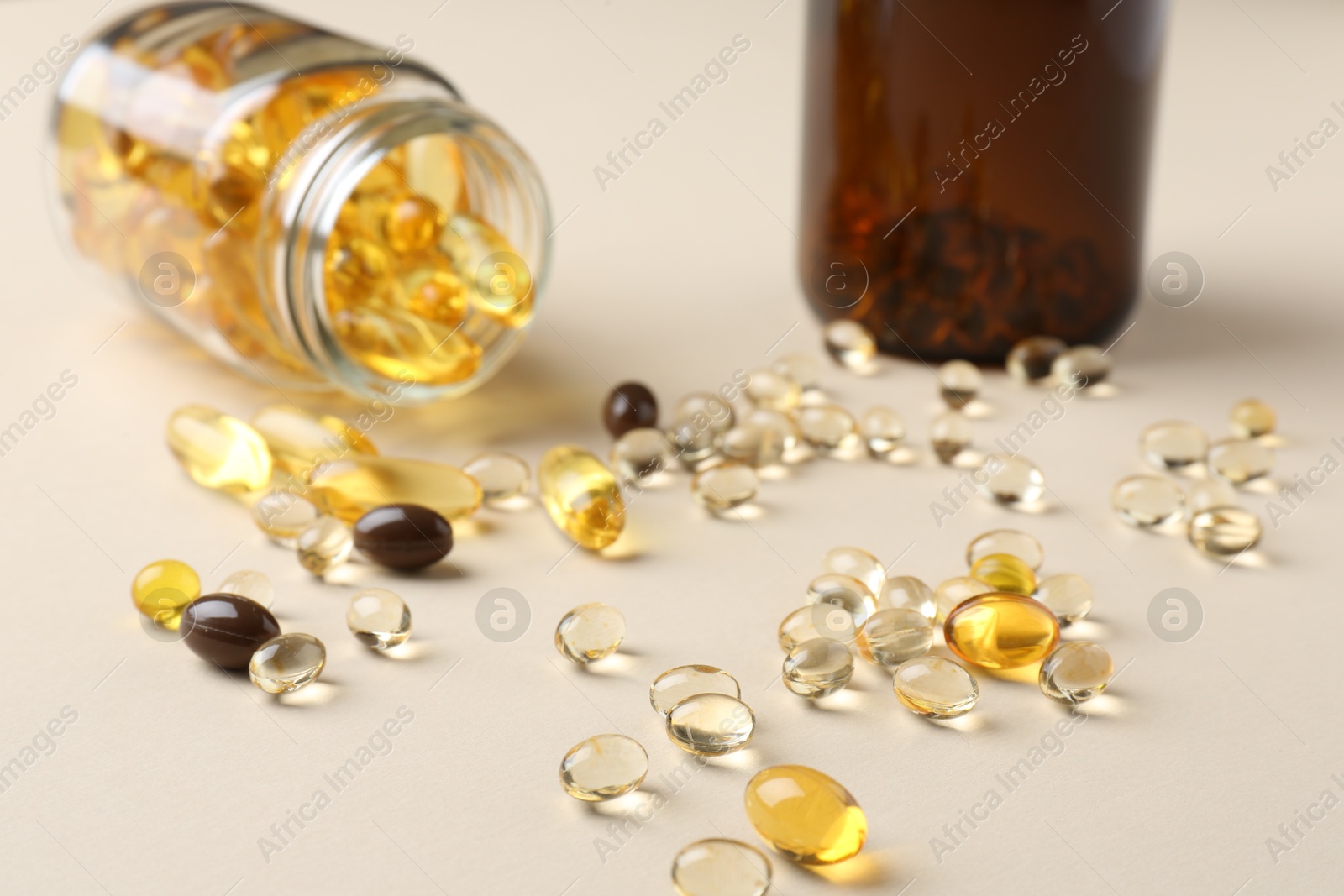 Photo of Pharmacist. Many different pills and overturned bottle on beige background, closeup