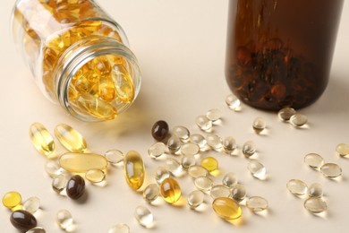 Pharmacist. Many different pills and overturned bottle on beige background, closeup