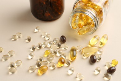 Photo of Pharmacist. Many different pills and overturned bottle on beige background, closeup