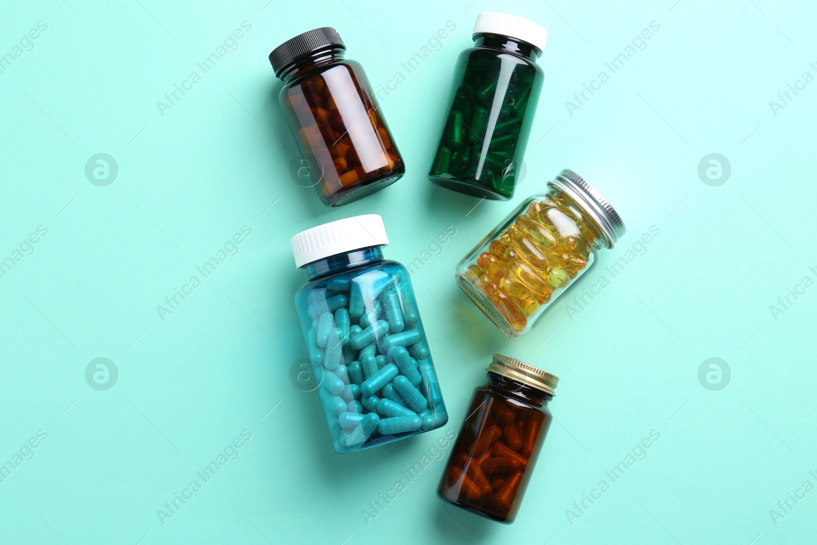 Photo of Pharmacist. Different pills in plastic bottles on light blue background, flat lay