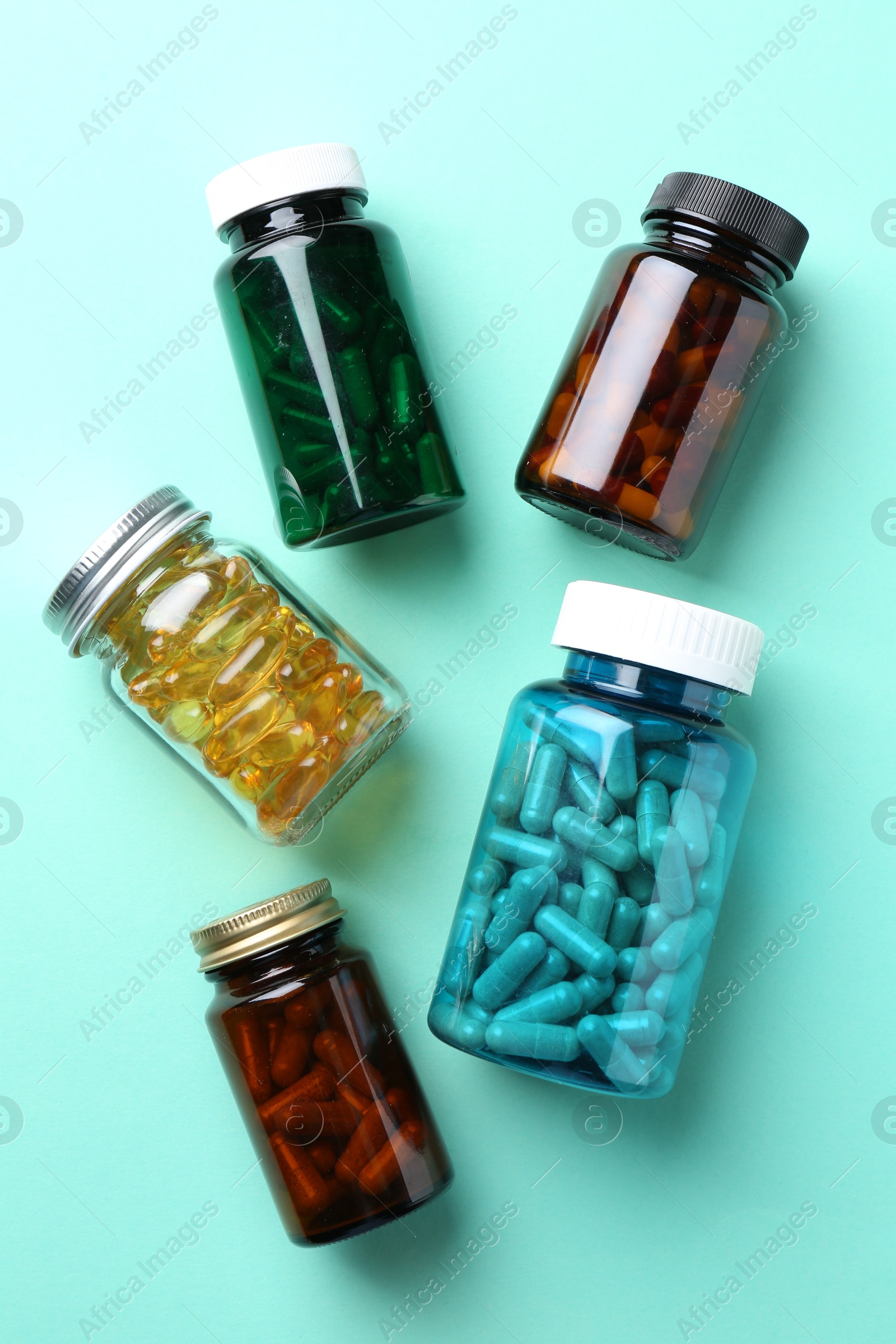 Photo of Pharmacist. Different pills in plastic bottles on light blue background, flat lay