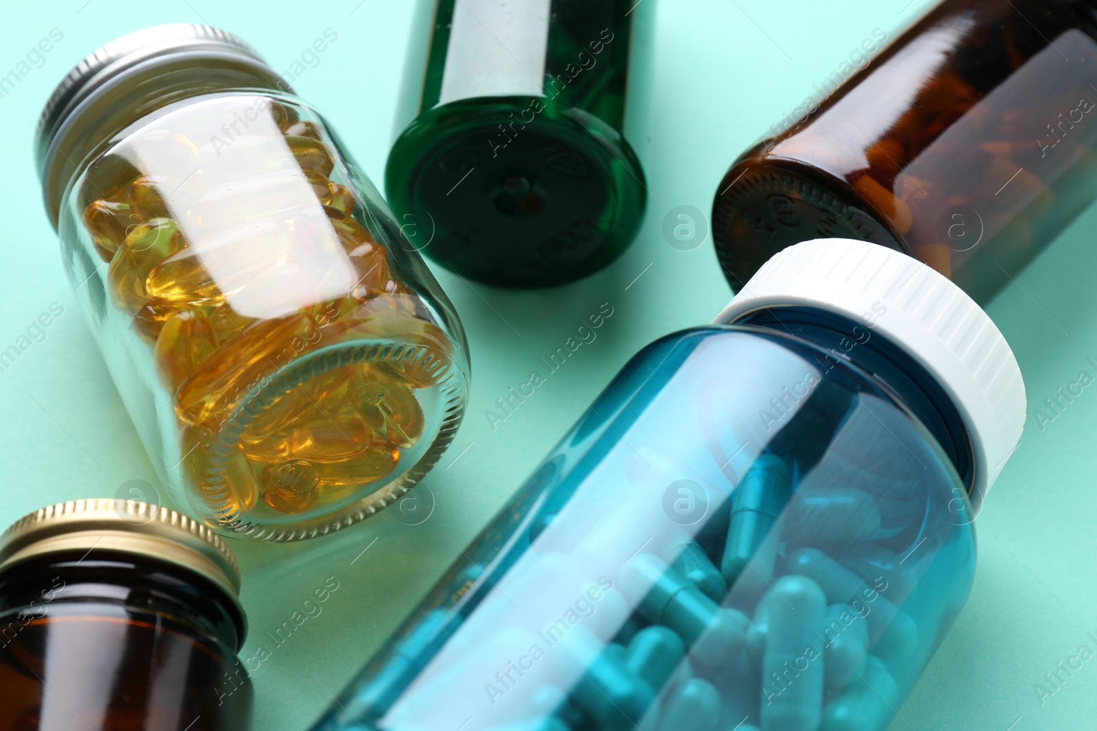 Photo of Pharmacist. Different pills in plastic bottles on light blue background, closeup