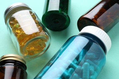 Pharmacist. Different pills in plastic bottles on light blue background, closeup