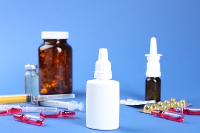 Pharmacist. Bottles of medical drops, pills ampoules and syringes on blue background