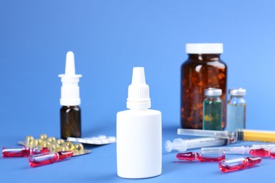 Pharmacist. Bottles of medical drops, pills ampoules and syringes on blue background