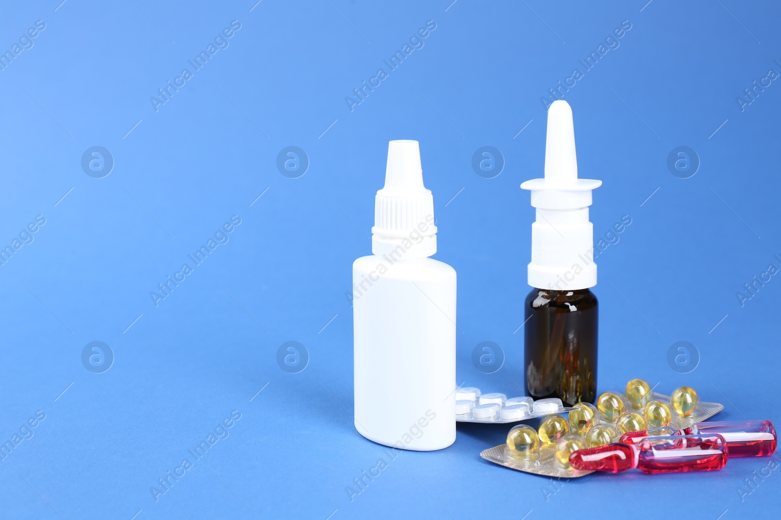 Photo of Pharmacist. Bottles of medical drops, pills and ampoules on blue background, space for text