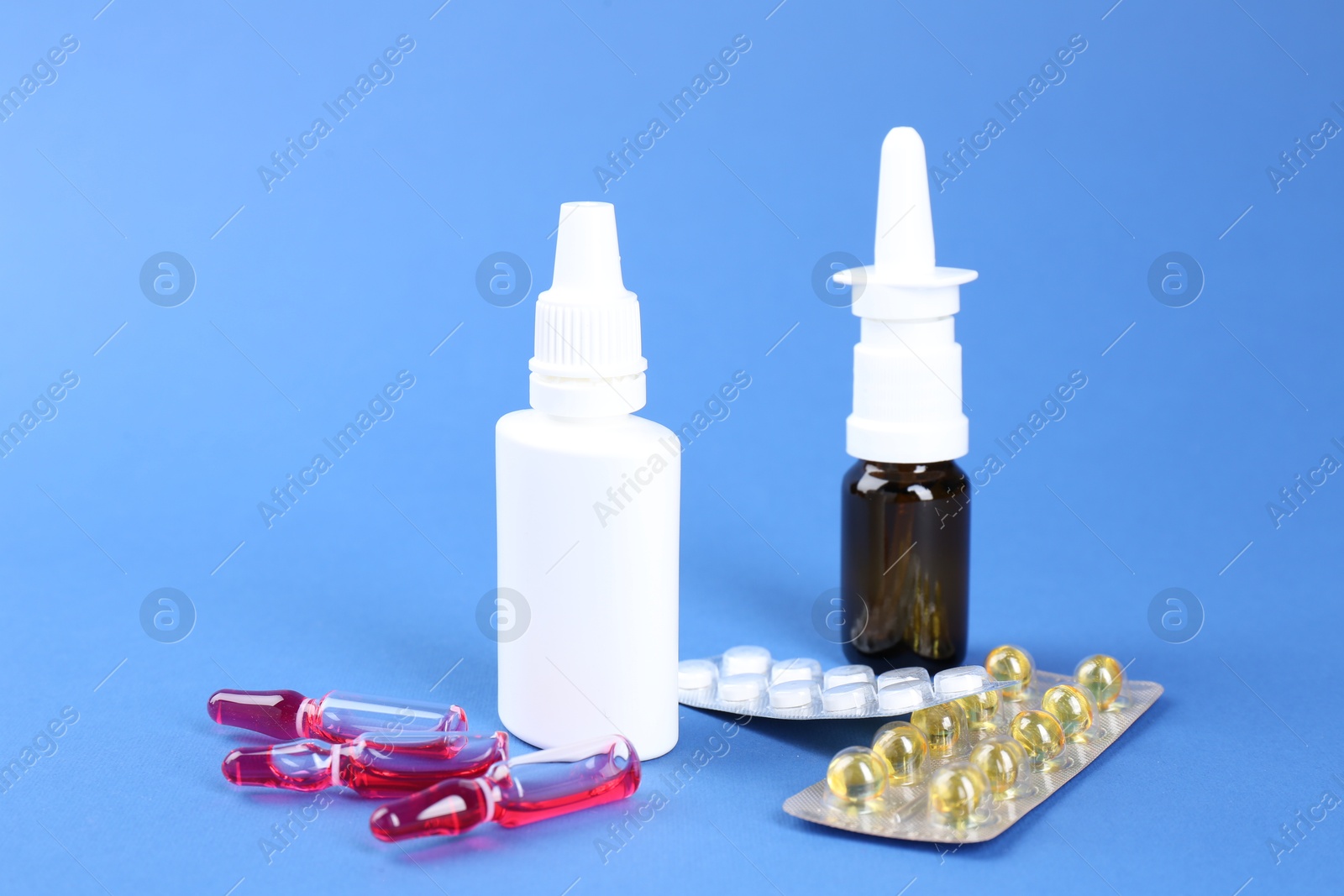 Photo of Pharmacist. Bottles of medical drops, pills and ampoules on blue background