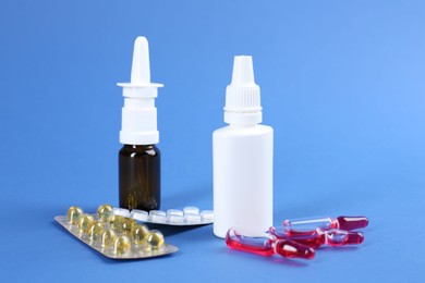 Photo of Pharmacist. Bottles of medical drops, pills and ampoules on blue background