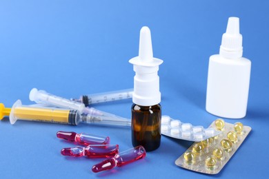 Pharmacist. Bottles of medical drops, pills ampoules and syringes on blue background