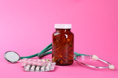 Pharmacist. Different pills and stethoscope on pink background