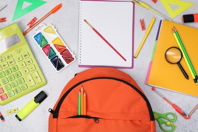 Photo of Flat lay composition with backpack and different school stationery on light grey table