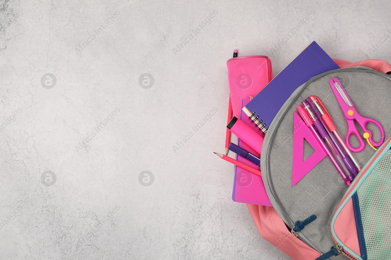 Photo of Flat lay composition with backpack and different school stationery on light grey table, space for text