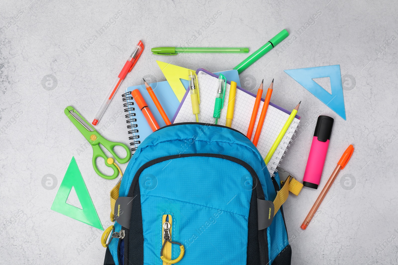 Photo of Flat lay composition with backpack and different school stationery on light grey table