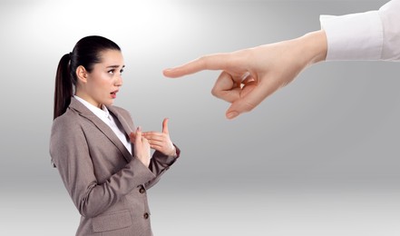 Image of Boss or colleague pointing at confused woman on grey background. Failure at work, responsibility, social pressure