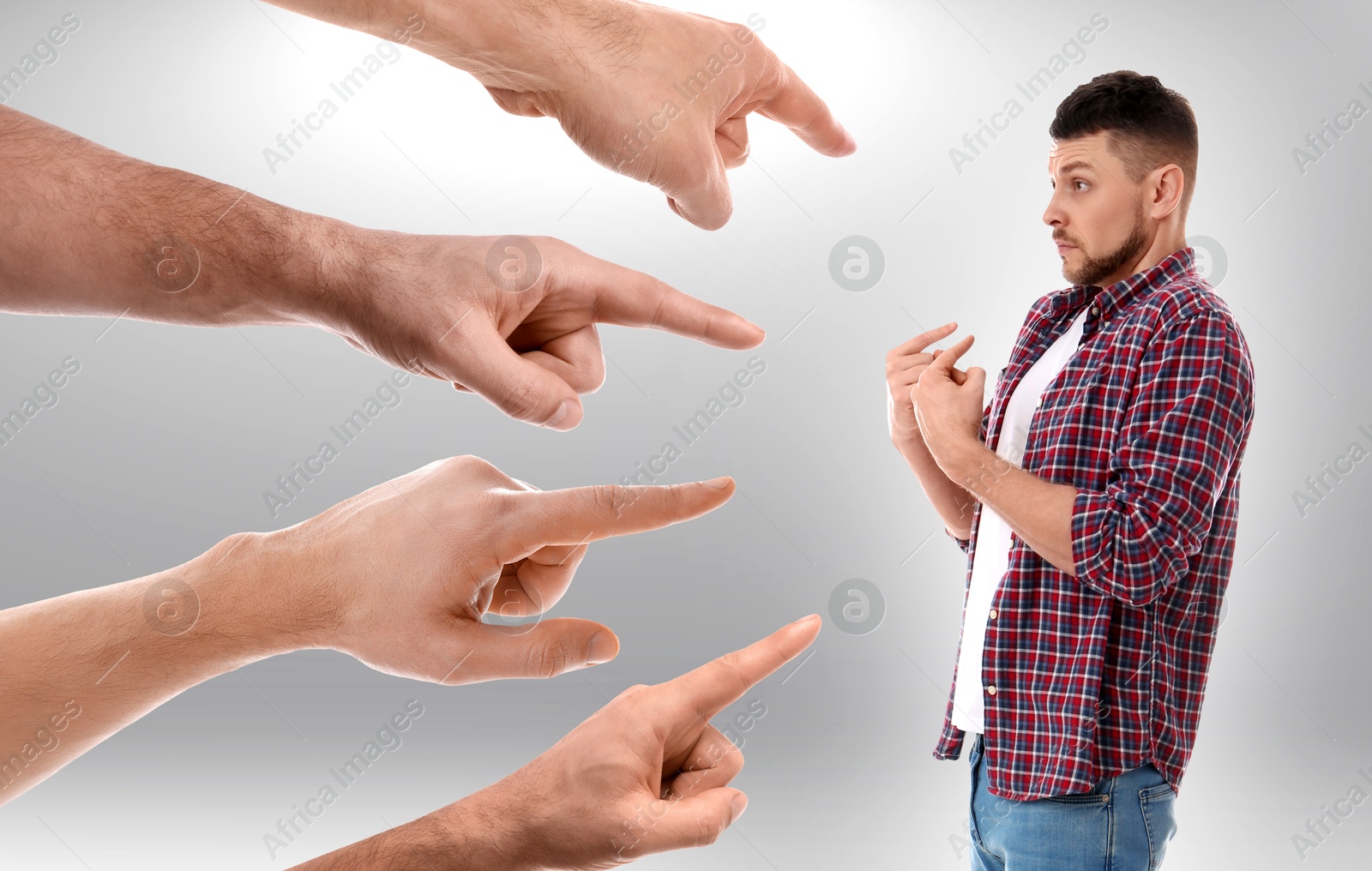 Image of People pointing at man on grey background. Failure, responsibility, social pressure