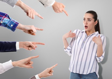 People pointing at confused woman on grey background. Failure, responsibility, social pressure