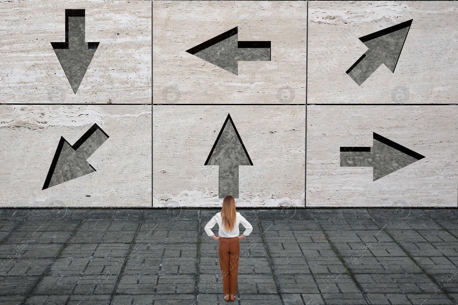 Image of Small businesswoman looking at wall with arrows pointing in different directions. Concept of choice