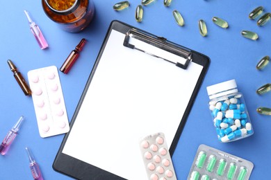 Pharmacist concept. Flat lay composition with clipboard and pills on blue background. Space for text