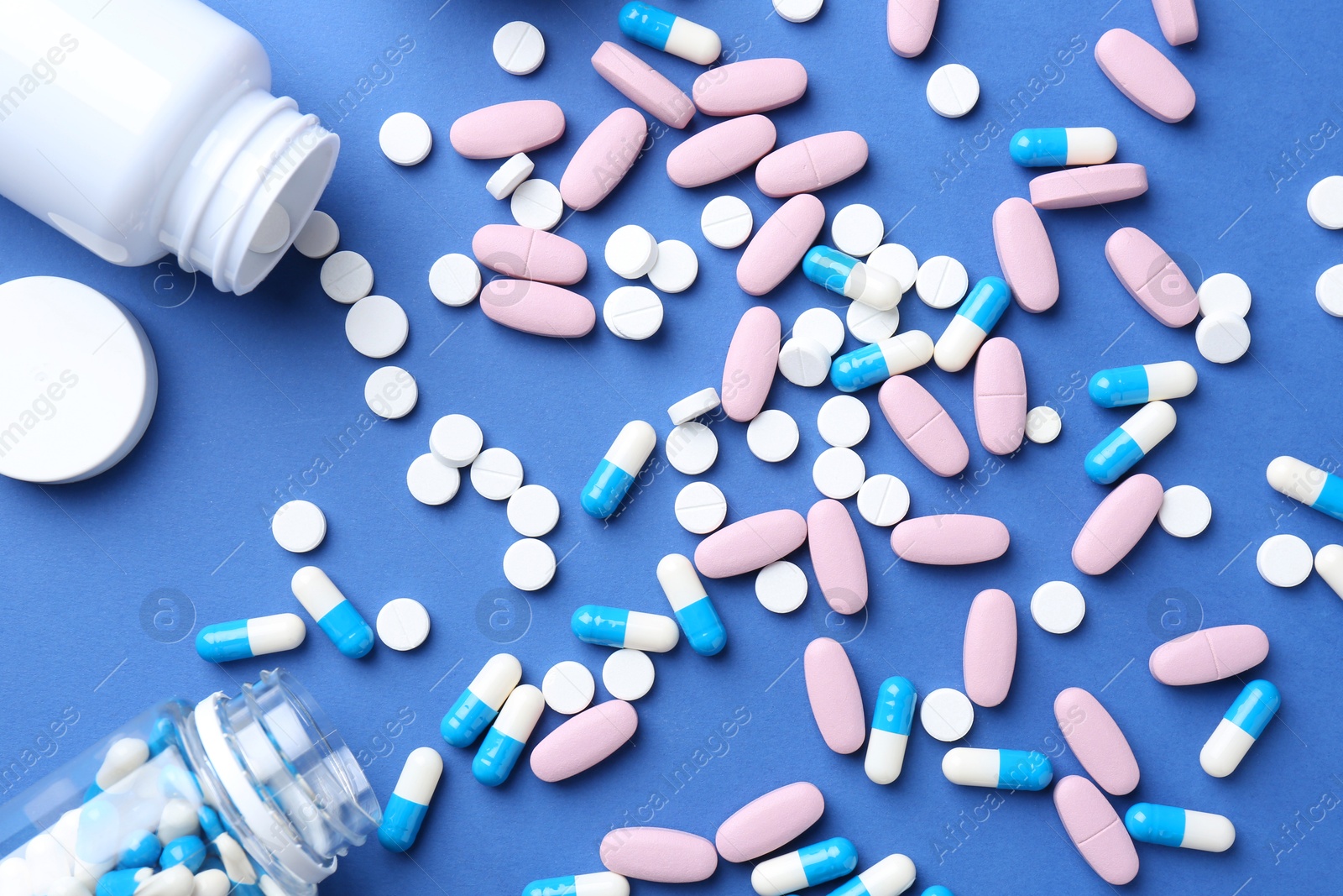 Photo of Pharmacist concept. Many different pills on blue background, flat lay