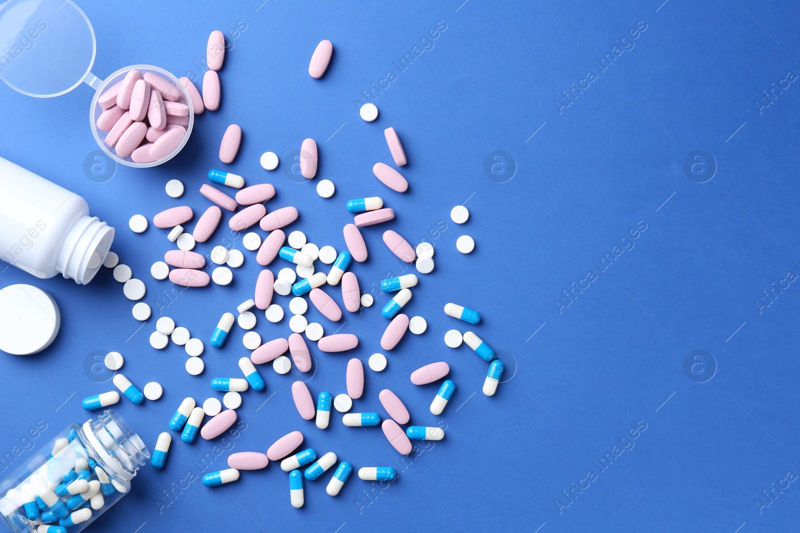 Photo of Pharmacist concept. Many different pills on blue background, flat lay. Space for text