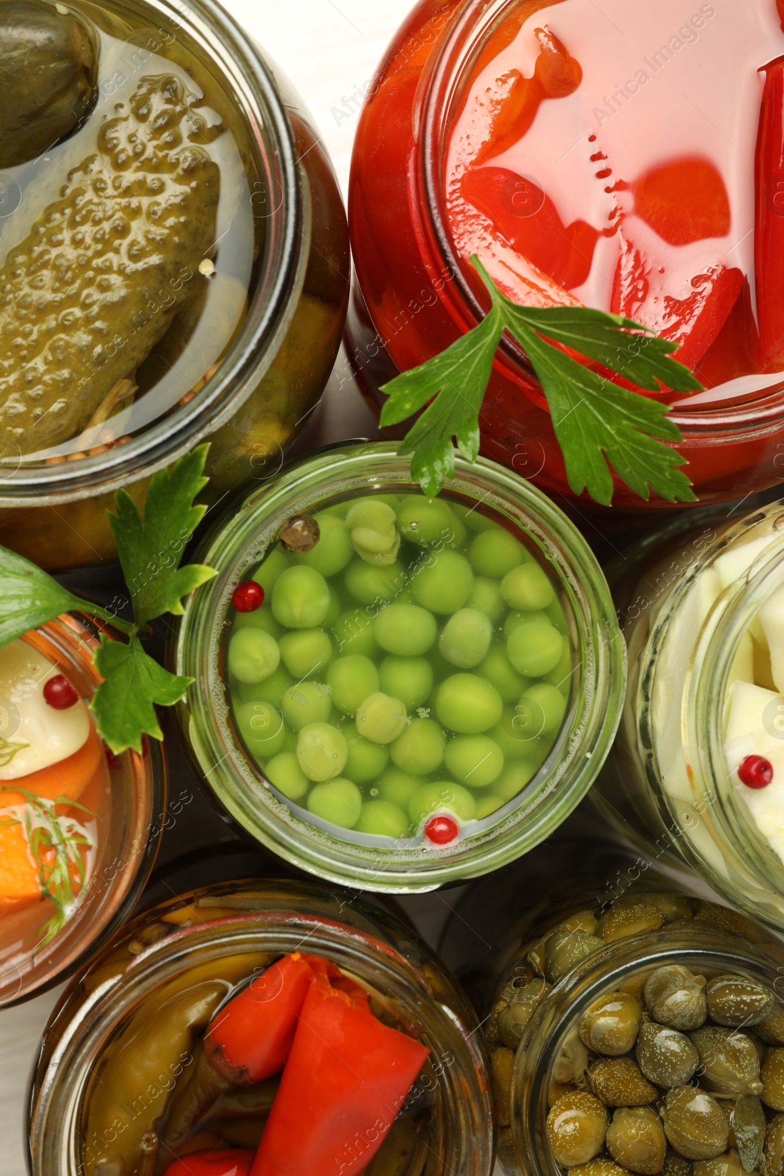 Photo of Different pickled products in jars on table, top view