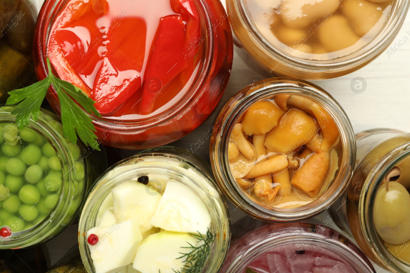 Photo of Different pickled products in jars on table, top view