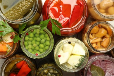 Photo of Different pickled products in jars on table, top view